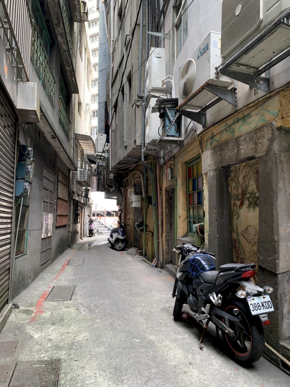 Porte arrière de la boutique dans une ruelle arrière, à hauteur de la moto